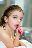 Little girl with lipstick on the bathroom