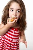 Pretty little girl eating a doughnut