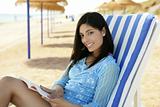 beautiful woman with a book relaxed on the beach