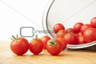 Washed Tomatoes in Colander on Cutting Board