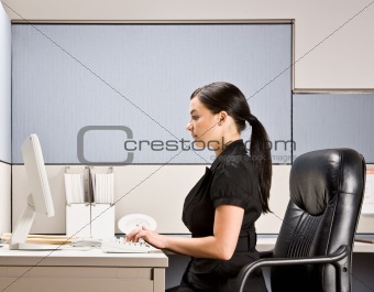 Businesswoman typing on computer at desk