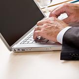 Close up of businessman typing on laptop