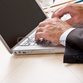 Close up of businessman typing on laptop