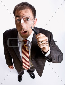 Businessman looking through magnifying glass