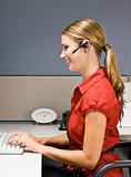 Businesswoman talking on headset at desk