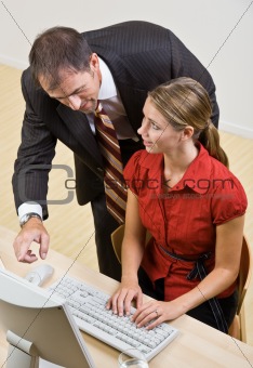 Businessman helping co-worker at computer