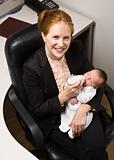 Businesswoman feeding baby at desk