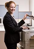 Businesswoman copying papers in office