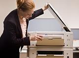 Businesswoman copying papers in office