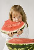 Little girl holds a slice of the watermelon and eats his