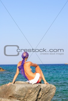 Beautiful girl meditating on the beach