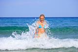 tanned blond woman in bikini in the sea