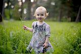 Smiling baby girl in a meadow