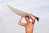 young man holding a surf board outdoors