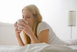 Woman in Bed With Coffee Cup