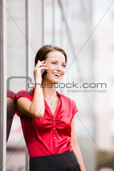 Woman Leaning Against Building and Using Cell Phone