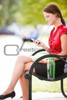Woman On Bench With MP3 Player