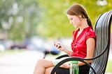 Woman Sitting On Bench With MP3 Player