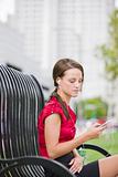 Woman Outside On a Park Bench Listening to Headphones