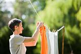 Woman Hanging Orange Shirt on a Clothesline
