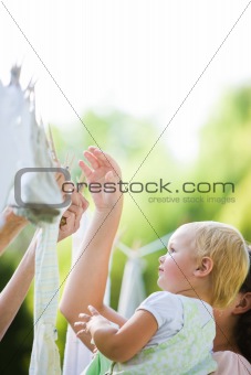 Child Helping Mom Hang Laundry on Clothesline