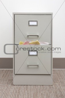 Detail of a full filing cabinet with blank drawer labels.