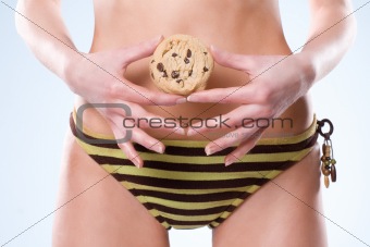 Woman waist down wearning a swimsuit and holdling a cookie