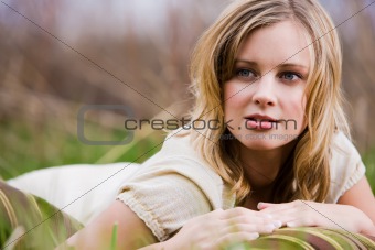 Woman lying on her stomach in the grass