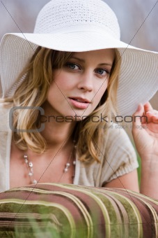 Woman wearing a white hat and posing with pillow