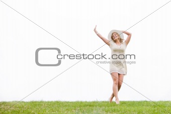 Woman In Meadow With Arms Outstretched