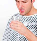 Patient taking a pill and holding a glass of water