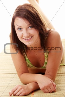 Lady wearing swimsuit on bamboo mat