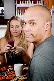 Bored man with woman on cell phone