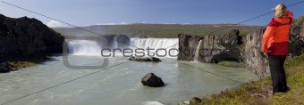 Panorama of Woman Hiker Looking At Godafoss Waterfall, Iceland