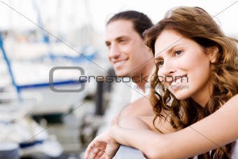 Happy couple looking away, harbour view
