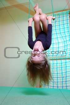 child at her home sports gym swinging