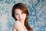 beautiful Asian lady in front of mosaic and looking