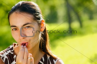 Young woman eating a cherry