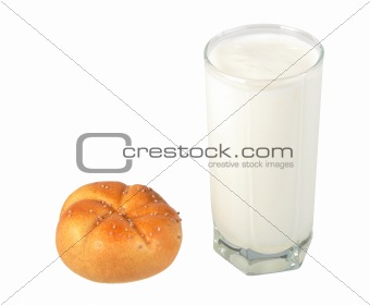 Milk in transparent glass and yellow-orange bagel.