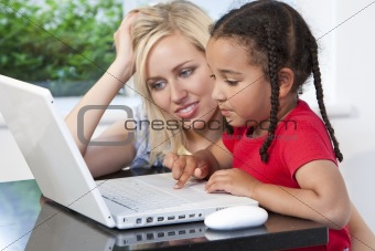Mixed Race Mother and Daighter Using Laptop Computer At Home