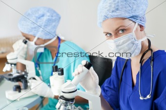 Female Scientists or Doctors Using Microscopes in a Laboratory