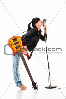 Rock-n-roll girl holding a guitar kissing retro microphone isolated on white