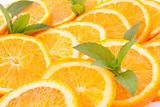 Many sliced oranges and green mint