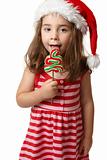 Santa girl licking Christmas tree lollipop candy