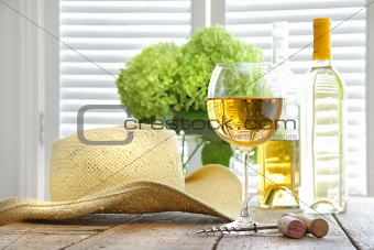 Glass of wine with straw hat on table