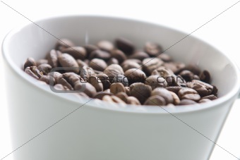 Cup of coffee filled with coffee beans