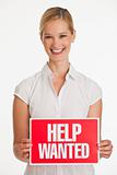 Small business owner holding up Help Wanted sign
