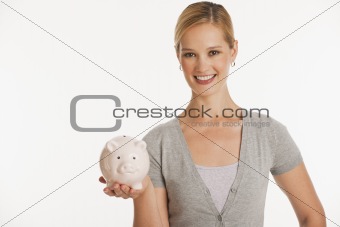 young woman holding up piggy bank