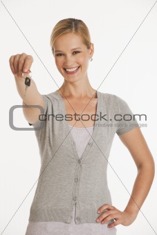 young woman holding out keys towards camera