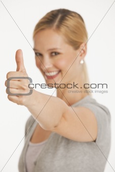 young woman giving thumbs up towards camera